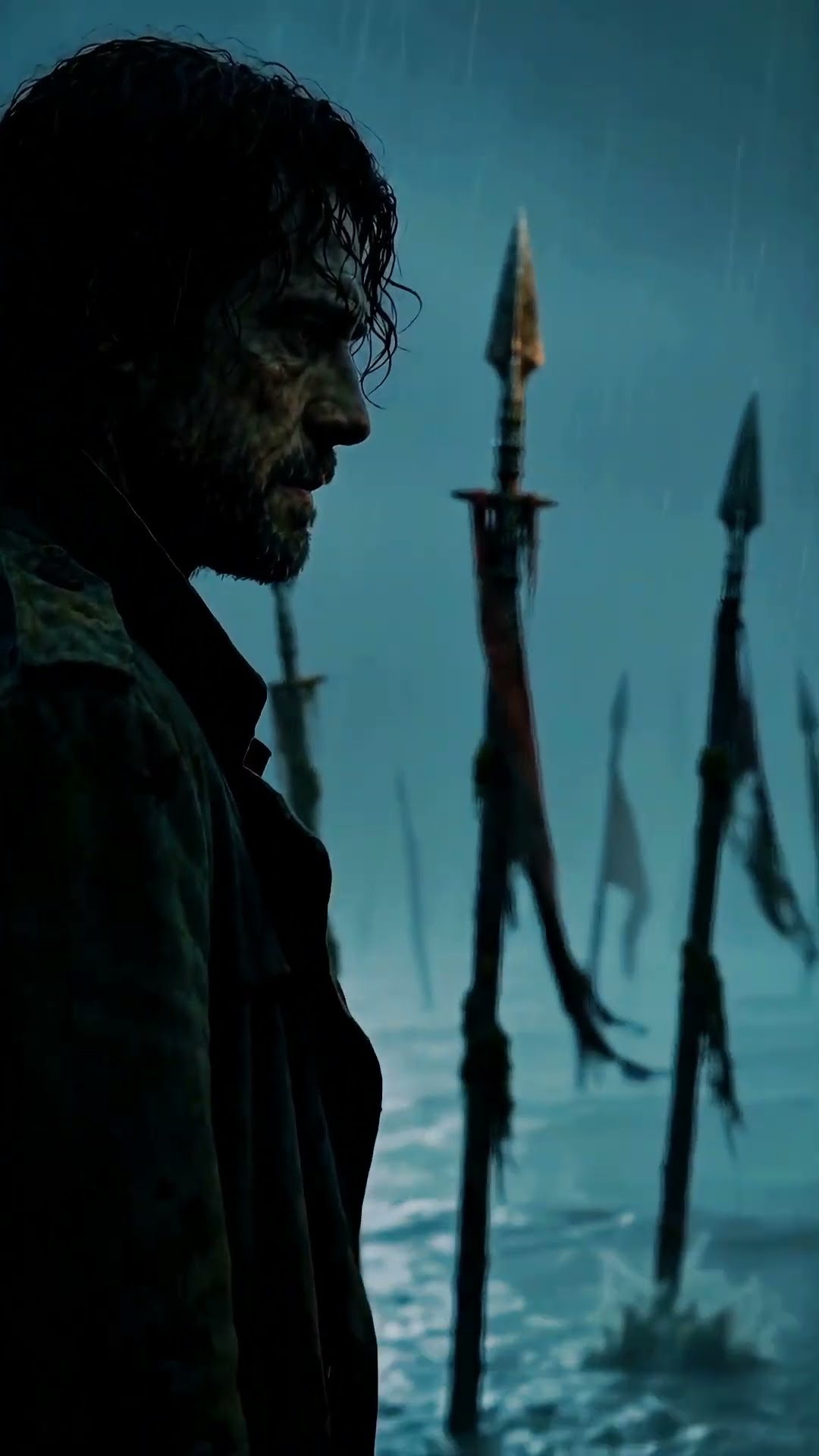 A bearded man in a dark coat stands in profile in the rain, spears rising from shallow water behind him.